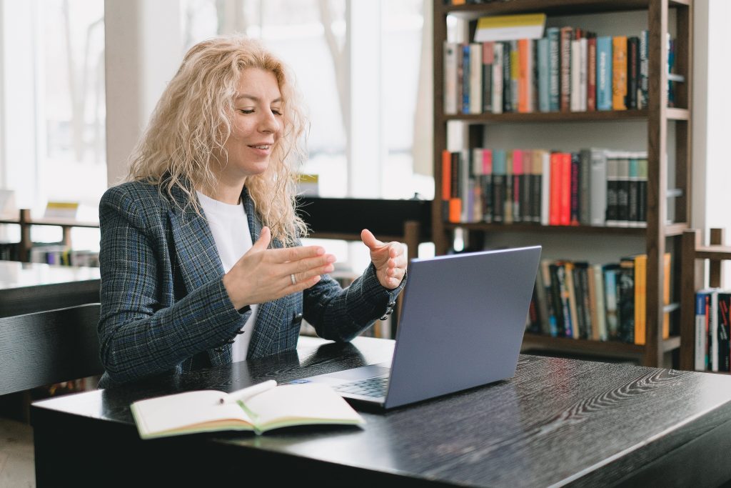 a woman sitting at a table using a laptop