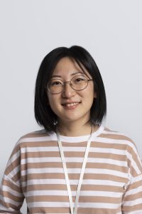 Portrait of a Progressive Learning Academy tutor wearing glasses and a striped shirt, smiling in a professional headshot with a neutral background.