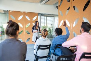 Beautiful young woman working with audience Beautiful young woman working with audience. Smiling manager responding to questions. Business training concept