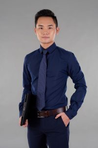 Portrait of handsome young businessman with clipboard looking at camera